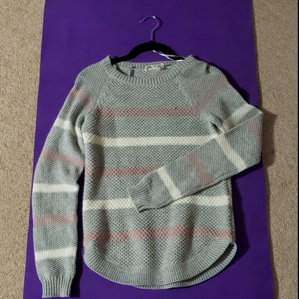 Gray knitted sweater with white and pink stripes.